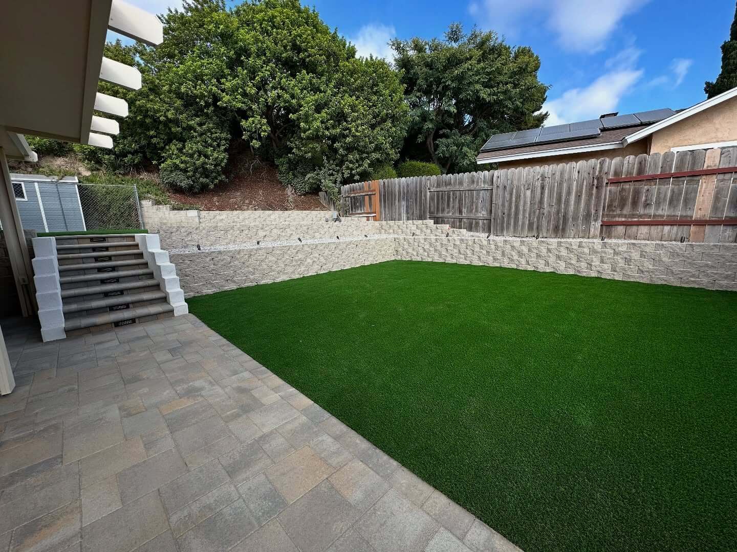 Retaining wall with artificial turf installed by New Age Design and Build